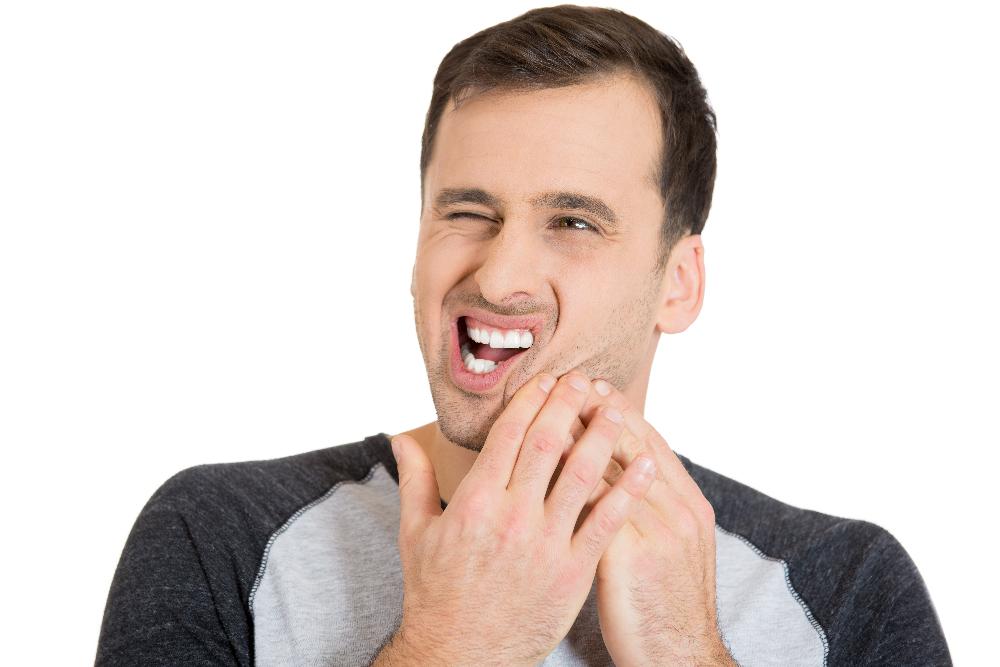 man holding jaw from tooth ache