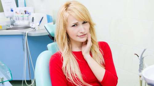 belmont woman holding jaw from dental pain